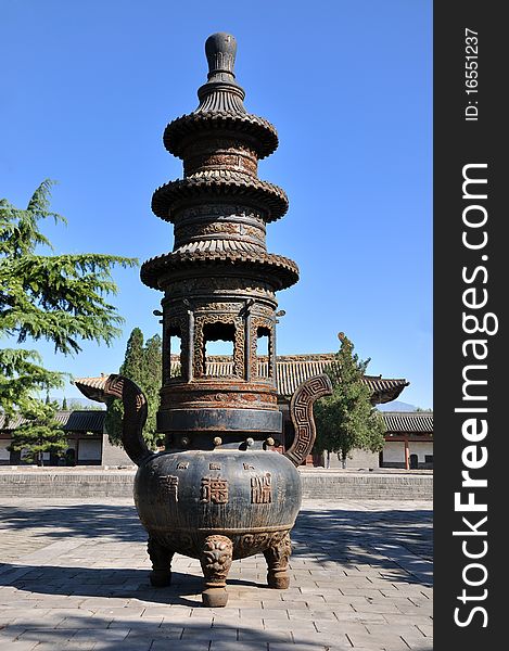 Old censer in Chinese traditional courtyard, surround with traditional architecture and trees.