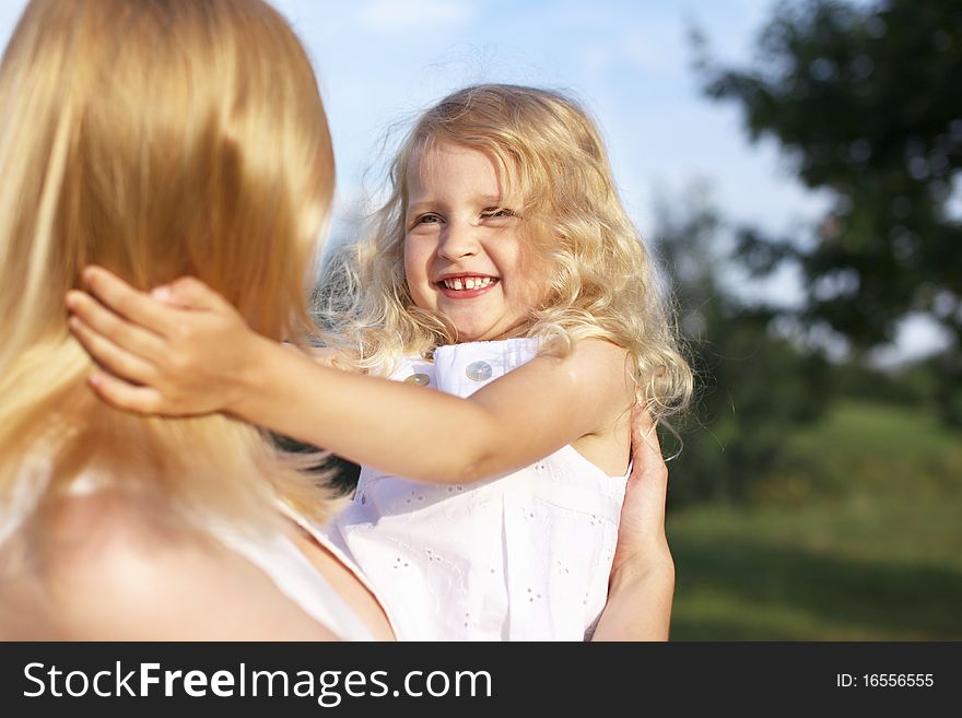 Laughing little girl in mother arms