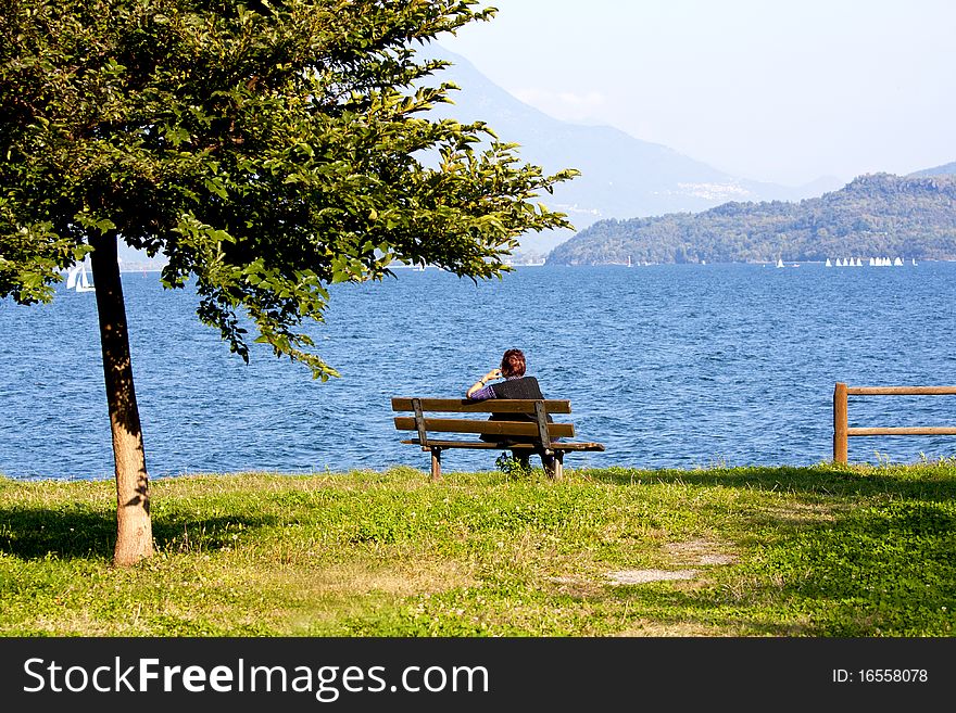Woman sitting on the bench by the lake. Woman sitting on the bench by the lake