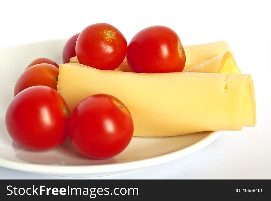 Red-ripe cherry tomatoes with sliced and rolled up cheese. Red-ripe cherry tomatoes with sliced and rolled up cheese