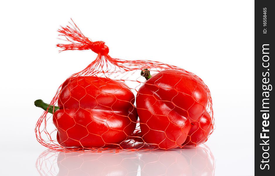 Red paprica in mesh bag on white background