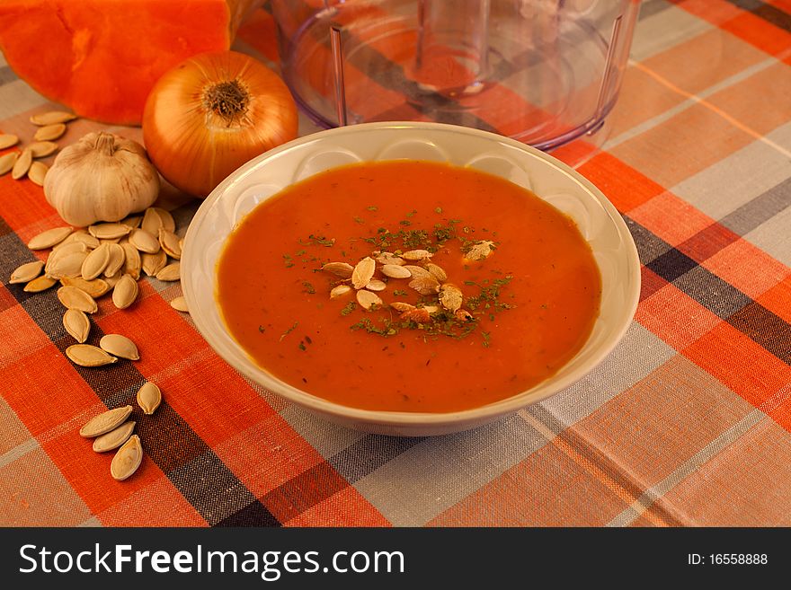 Hot pumpkin soup with garlic and decorated pumpkin seeds