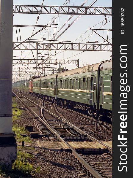 Russia. Locomotive with a green wagon rides on railway track