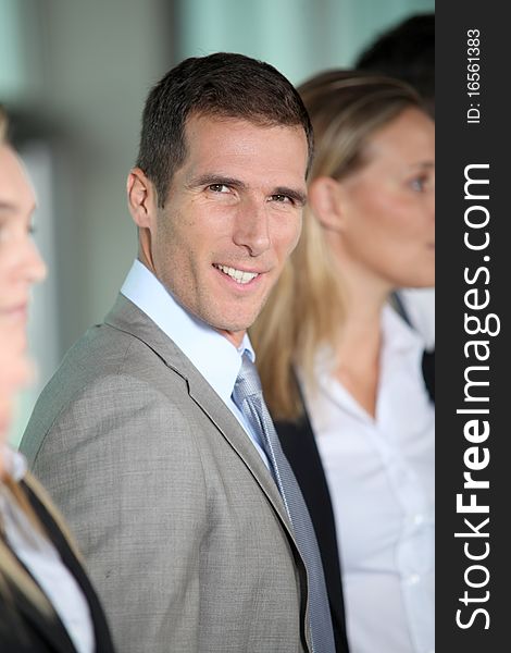 Smiling businessman in front of group. Smiling businessman in front of group