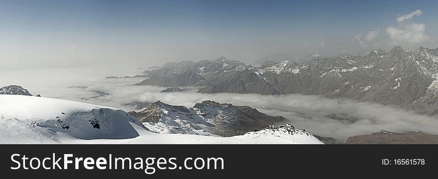 Panorama image of the misty Alpine mountains. Panorama image of the misty Alpine mountains