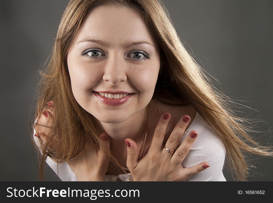 Beautiful woman smiles on a grey background