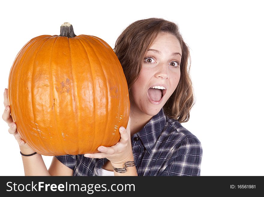 A woman in a blue shirt is holding a big pumpkin. A woman in a blue shirt is holding a big pumpkin.