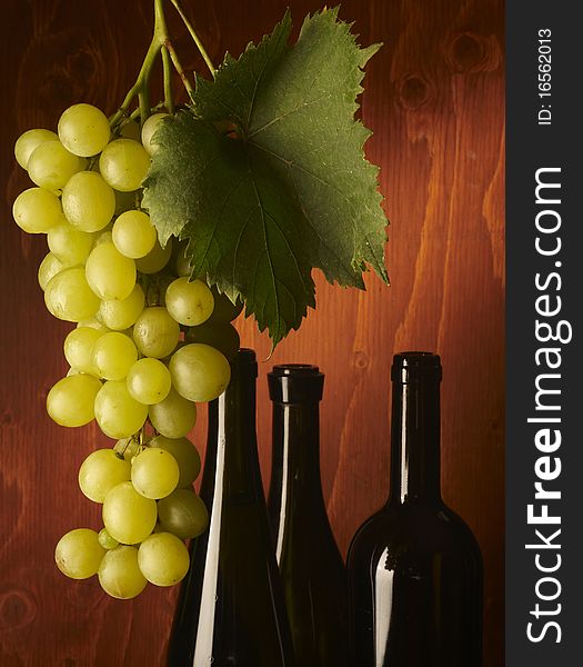 Bunch of grapes on wood,with bottle of wine