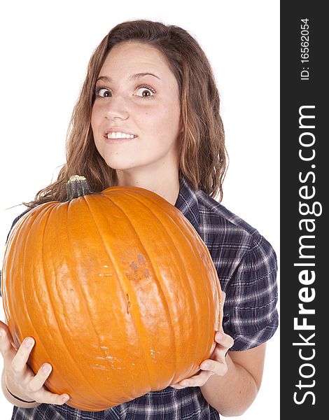 A woman in a blue shirt is holding a big pumpkin. A woman in a blue shirt is holding a big pumpkin.