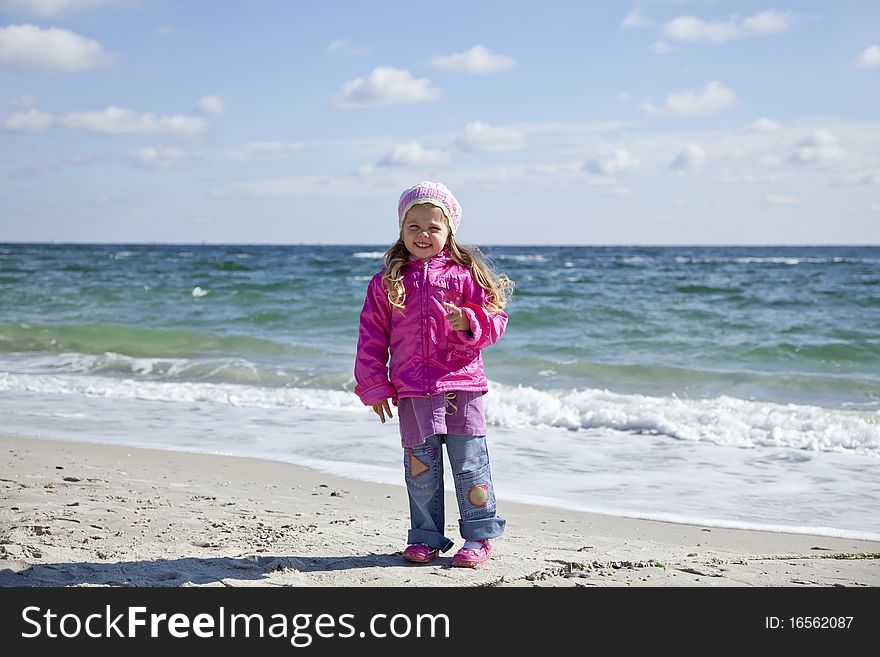 Cute young girl having fun on the beach. Outdoor photo.
