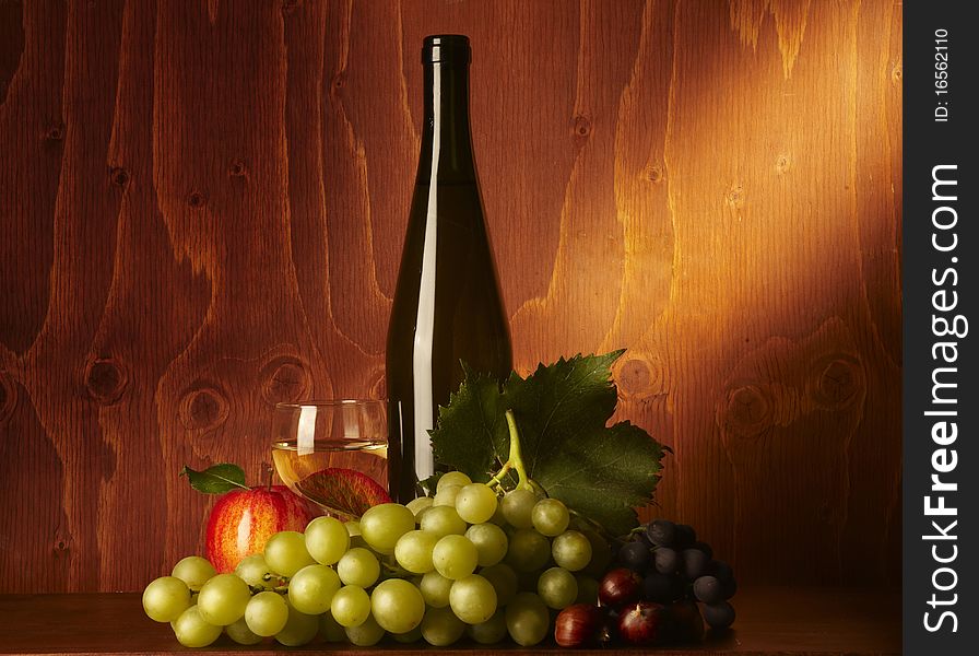 Bunch of grapes on wood,with bottle of wine. Bunch of grapes on wood,with bottle of wine