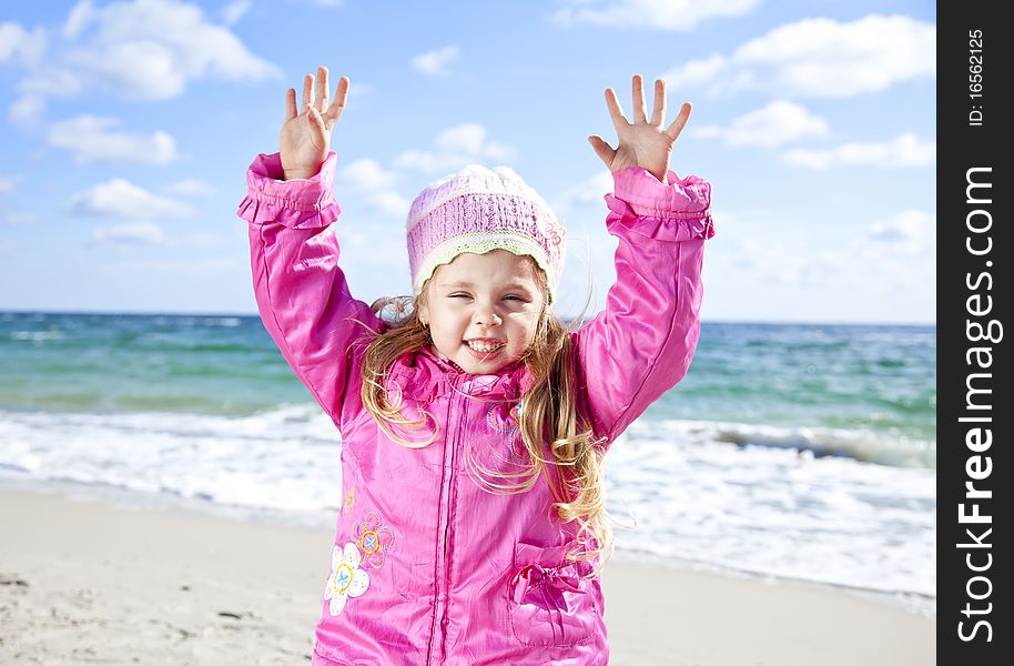 Cute young girl having fun on the beach. Outdoor photo.