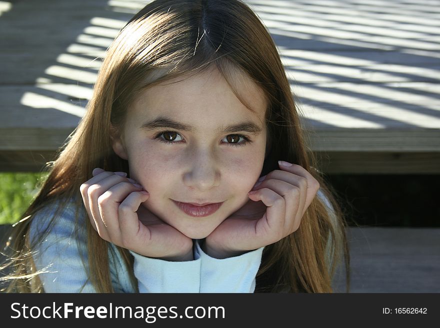 Pre teen girl sitting on steps with chin in hands