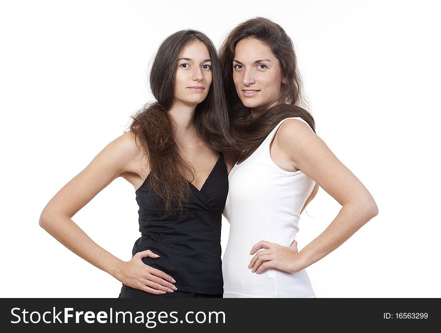Two sisters with long brown hair holding each other, looking. Two sisters with long brown hair holding each other, looking