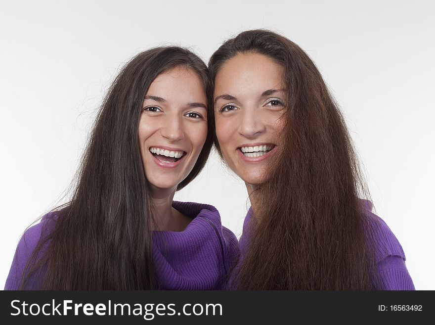 Two sisters with very long brown hair standing smiling. Two sisters with very long brown hair standing smiling