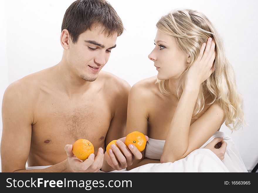 Young couple enjoying breakfast in bed. Young couple enjoying breakfast in bed