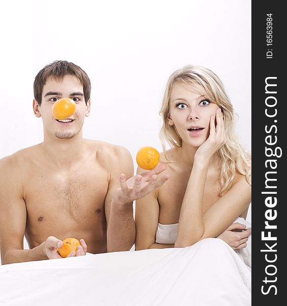 Young couple enjoying breakfast in bed. Young couple enjoying breakfast in bed