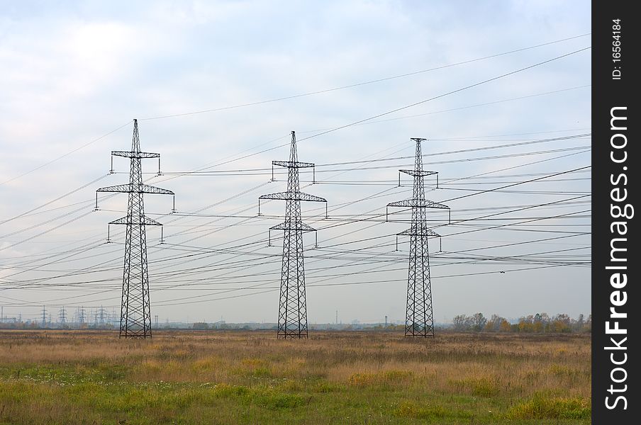 Steel power transmission towers in the background of the autumn sky. Steel power transmission towers in the background of the autumn sky