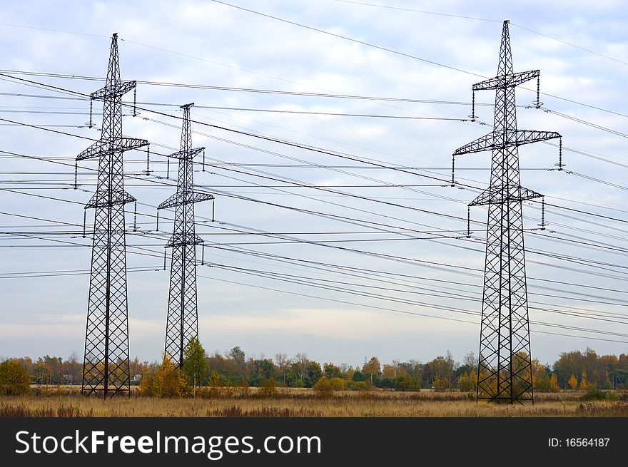 Steel power transmission towers in the background of the autumn sky. Steel power transmission towers in the background of the autumn sky