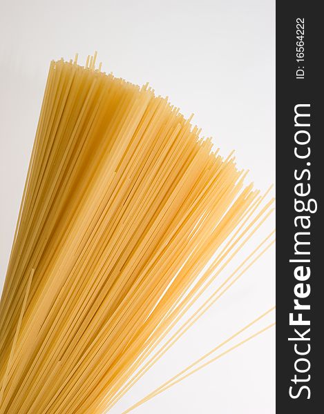 Noodless (spaghetti, pasta) made fom wheat flour on a white background