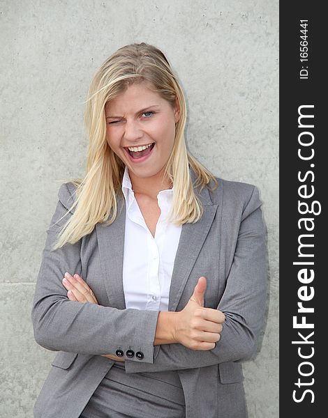 Blond businesswoman standing against a wall. Blond businesswoman standing against a wall