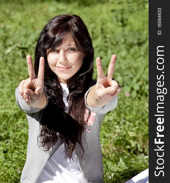 Brunette Girl On Green Grass In The Park.