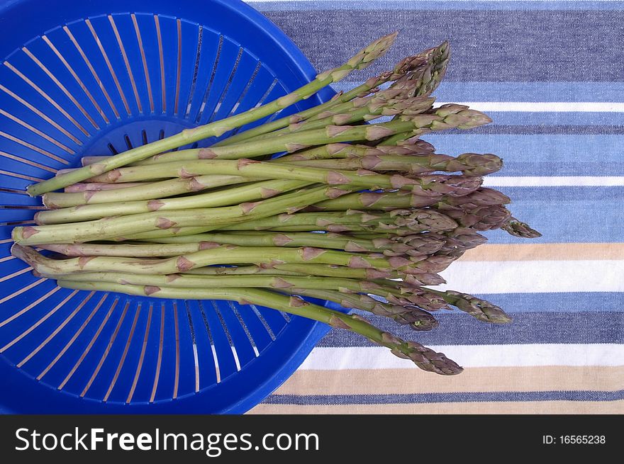 Fresh green Asparagus spears in colander on table