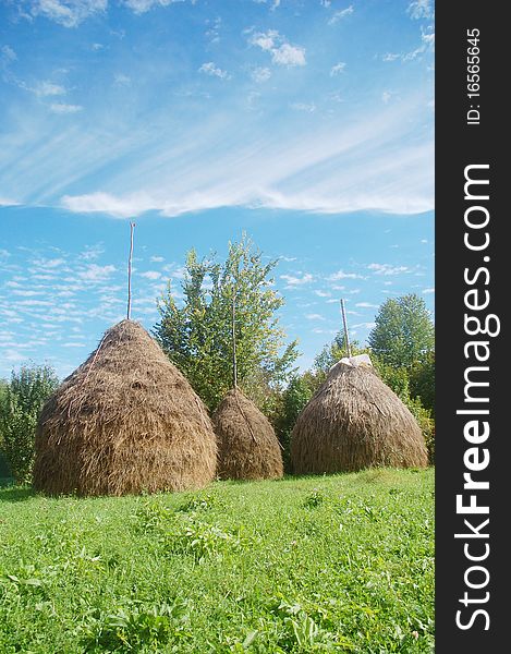 Stock of hay and beautiful clouds on the blue sky. Stock of hay and beautiful clouds on the blue sky