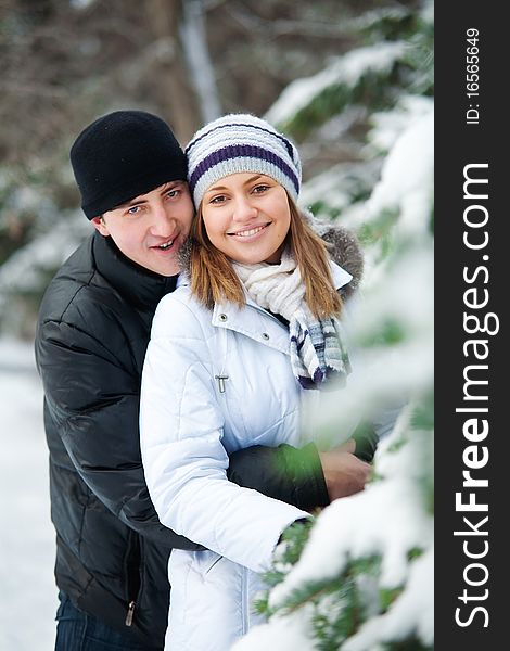 Portrait of young beautiful couple in winter park.
