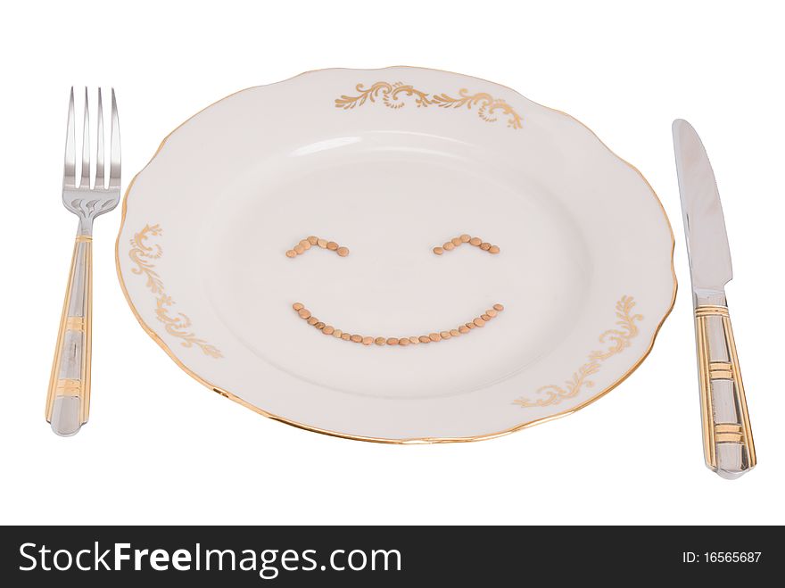 Plate, plug and knife on a white background, with clipping paths. On a plate the smilie from lentil is represented. Plate, plug and knife on a white background, with clipping paths. On a plate the smilie from lentil is represented