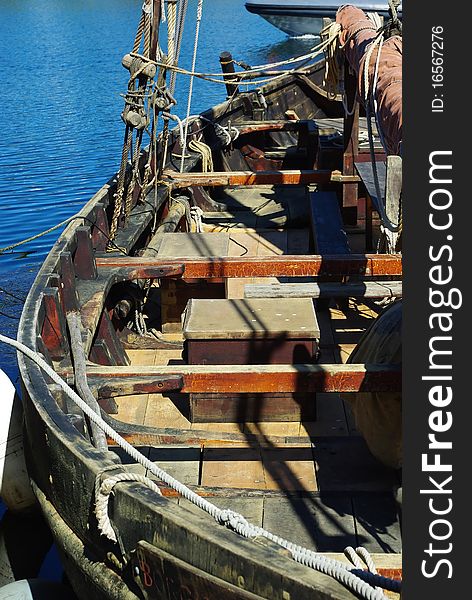 Equiped ancient wooden sailboat berthed to the pier