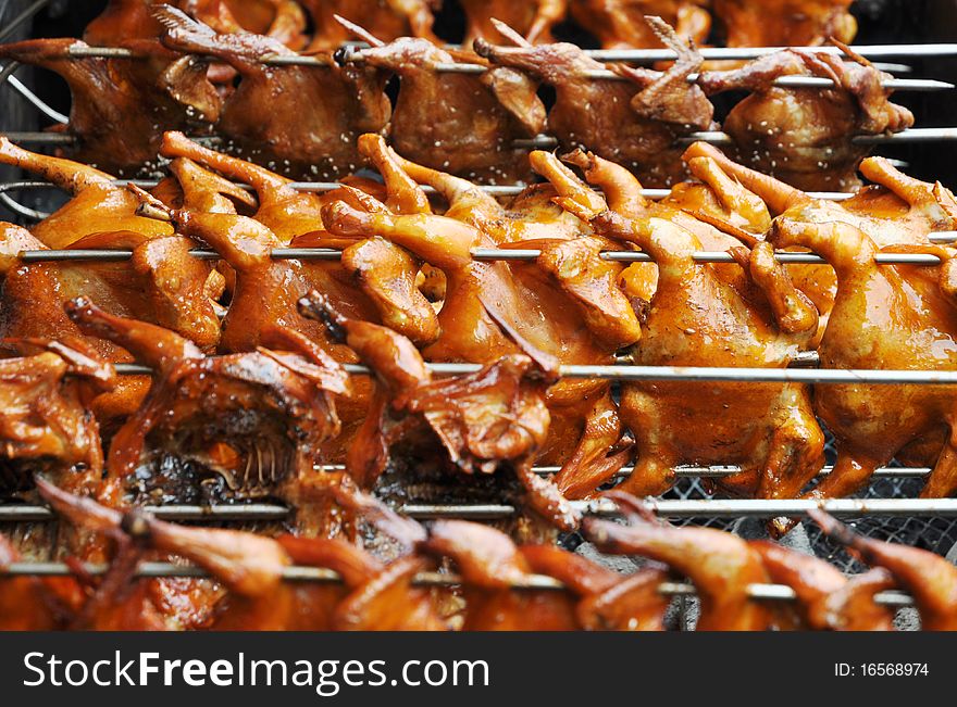 Fresh hot barbecued Chicken on steel skewers on fire.