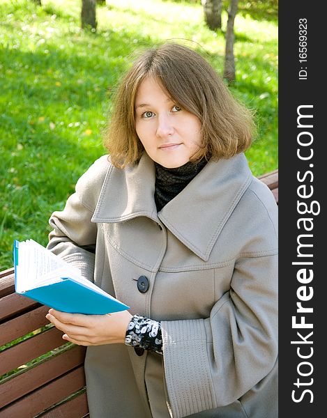 Attractive woman is reading a book outdoor