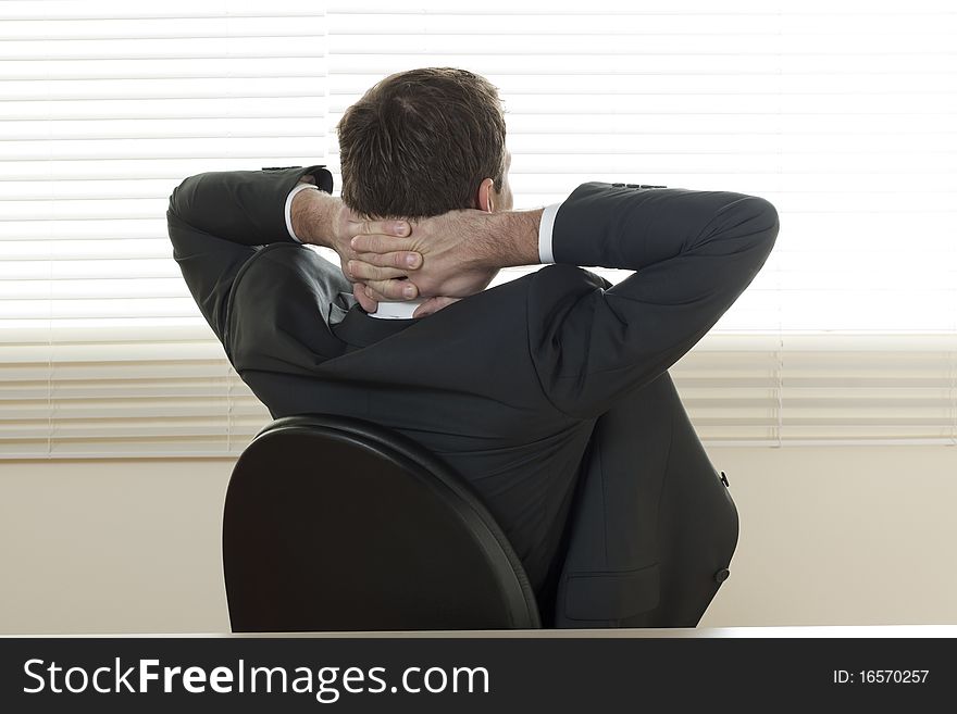 Rear view of a relaxed businessman with hands behind his head