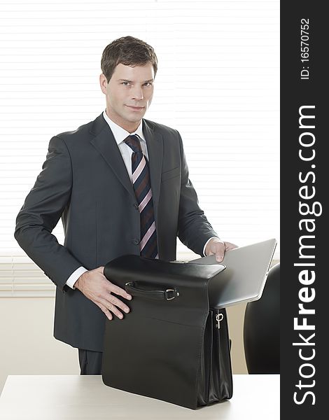 Businessman in his office with briefcase. Businessman in his office with briefcase