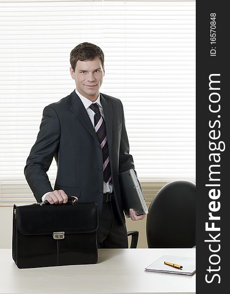 Businessman in his office with briefcase. Businessman in his office with briefcase