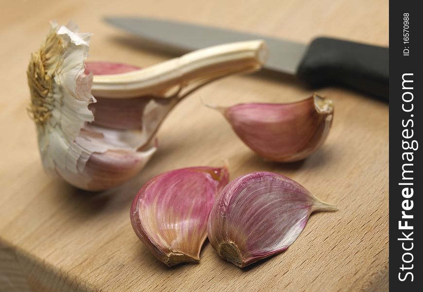 Garlic bulbs and cloves on wooden chopping board