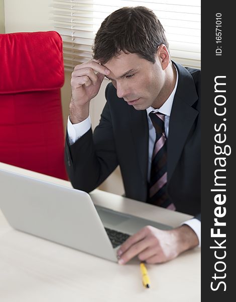 Businessman working on laptop in his office