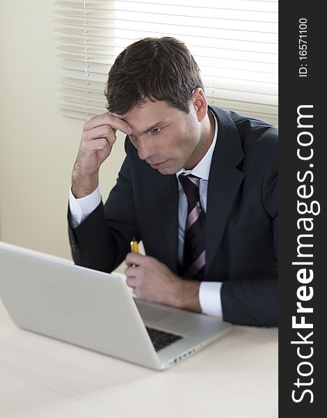 Concentrated Businessman working on laptop in his office