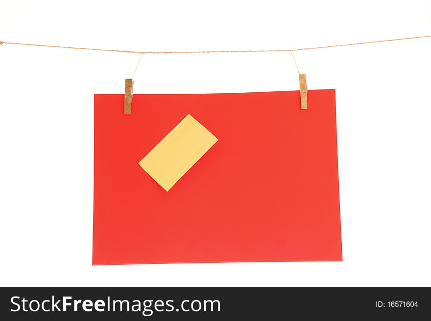 Red blank paper sheet on a clothes line. Isolated on white background. Red blank paper sheet on a clothes line. Isolated on white background.