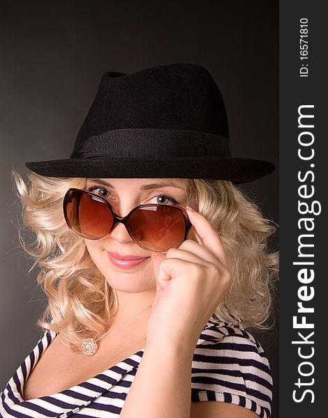Photo of beautiful young woman of blonde is in sunglasses and hat