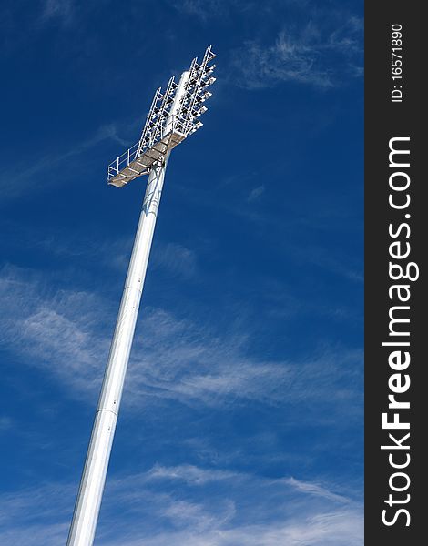 Stadium floodlight silhouetted against a dusky blue sky. Stadium floodlight silhouetted against a dusky blue sky