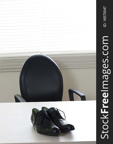 Male shoes on desk in the office