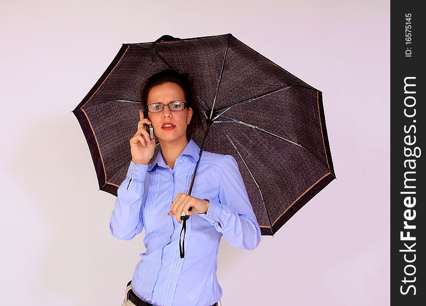 Portrait of girl holding the umbrella talking on cell phone. Portrait of girl holding the umbrella talking on cell phone