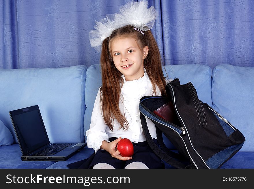 Schoolgirl with laptop, backpack and red apple