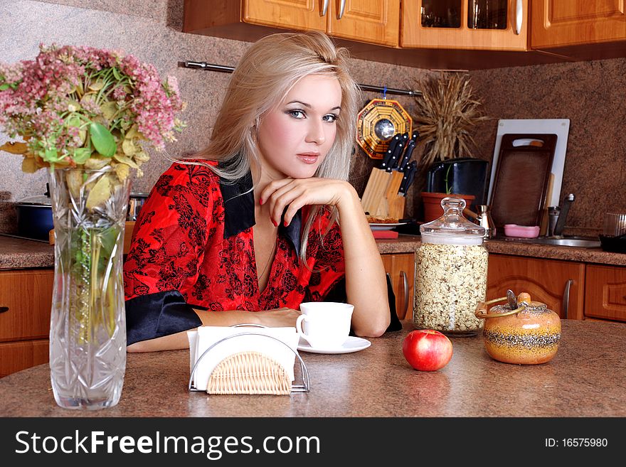 Woman breakfast with apple and cup of hot drink in the kitchen