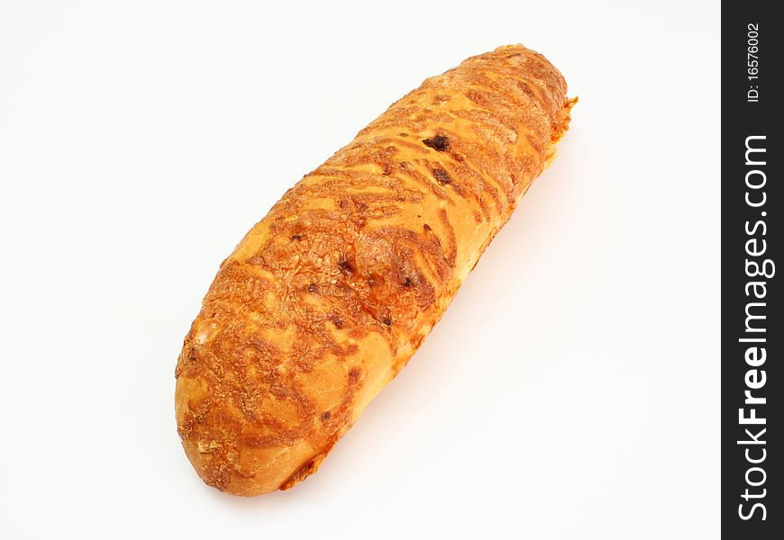The ruddy long loaf of bread is strewed by cheese isolated on a white background