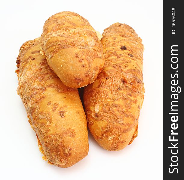 The ruddy long loaf of bread is strewed by cheese isolated on a white background