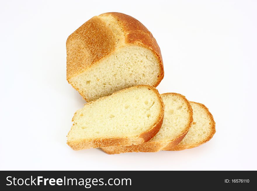 The ruddy long loaf of bread with the fried crust is isolated on a white background