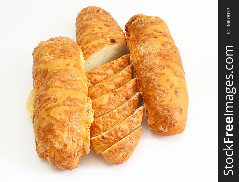 The ruddy long loaf of bread is strewed by cheese isolated on a white background